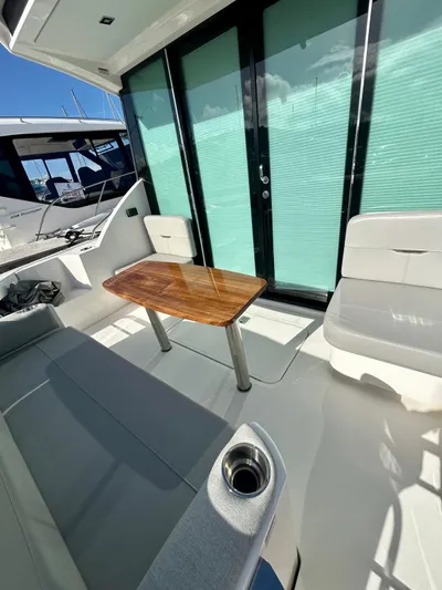  Yacht Photos Pics 2022 Tiara Yachts C39 Coupe interior with seating and wooden table.