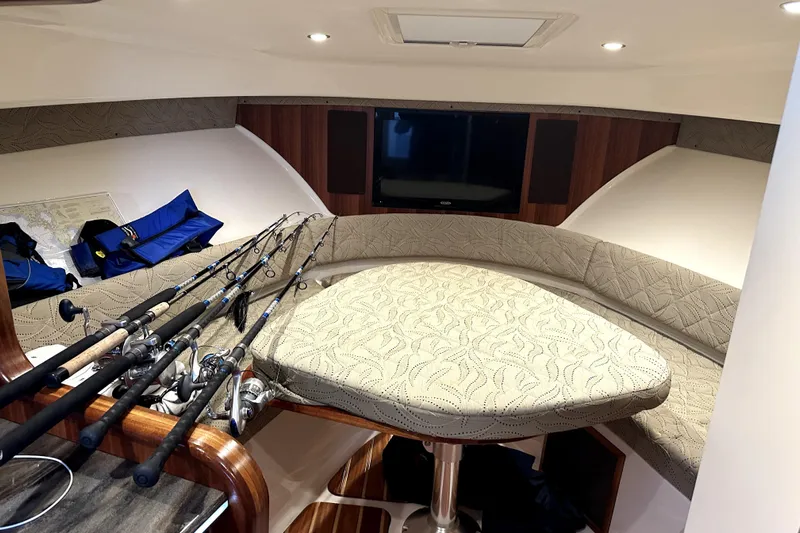 Change Of Pace Yacht Photos Pics Interior of 2014 PURSUITE 385 boat with fishing rods and cushioned seating.