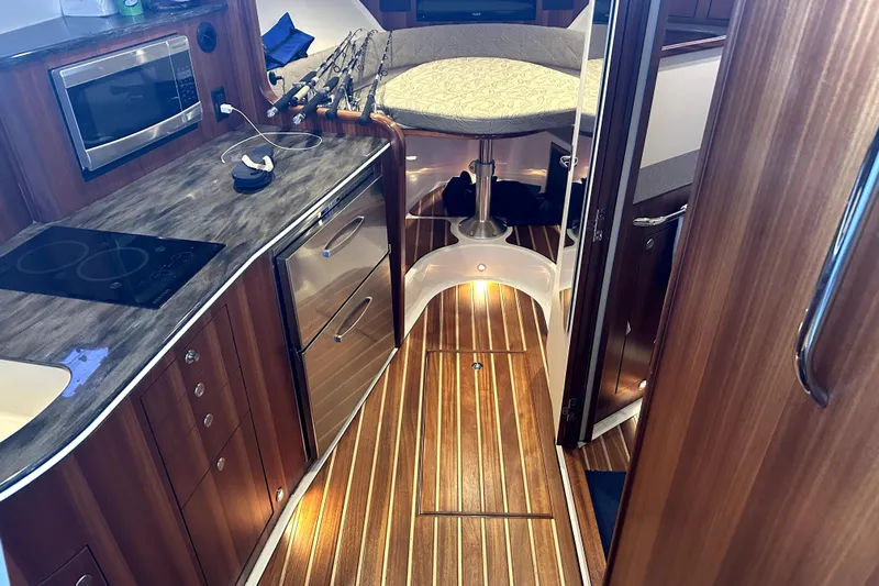 Change Of Pace Yacht Photos Pics Luxurious interior of 2014 PURSUITE 385 boat with modern kitchen and cozy seating area.