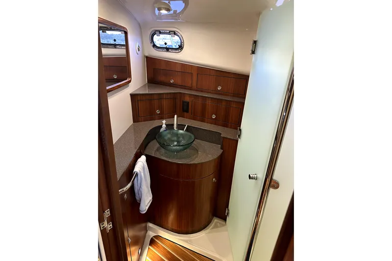 Change Of Pace Yacht Photos Pics Luxurious 2014 PURSUITE 385 yacht bathroom with wooden cabinetry and glass sink.