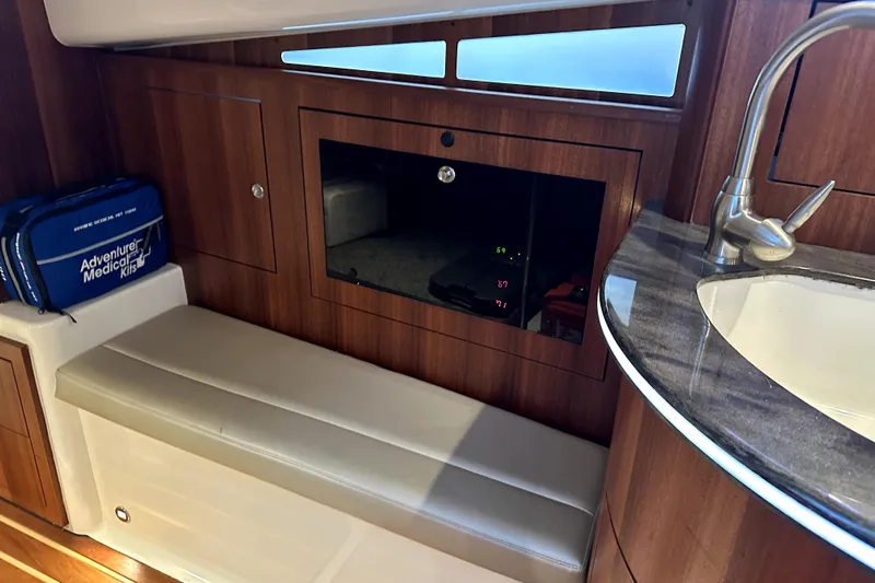 Change Of Pace Yacht Photos Pics Interior of 2014 PURSUITE 385 boat with medical kit, seating, and sink.