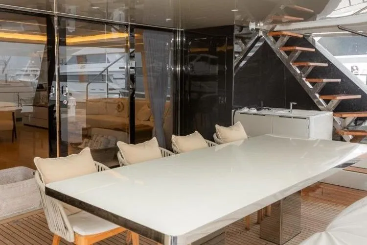 Fat Cat Yacht Photos Pics Luxurious Sunreef Fat Cat 2024 yacht interior with sleek dining area and modern staircase.