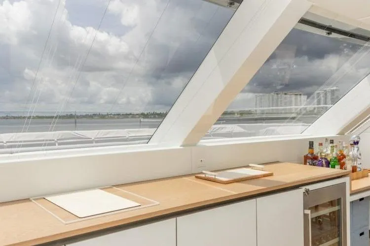 Fat Cat Yacht Photos Pics Luxurious Sunreef Fat Cat 2024 yacht interior with panoramic windows and modern bar setup.