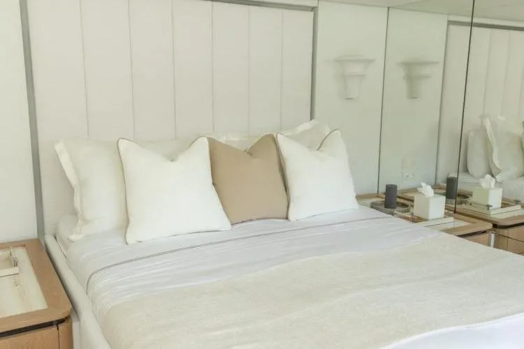 Fat Cat Yacht Photos Pics Luxurious bedroom interior on 2024 Sunreef Fat Cat yacht with elegant bedding and mirrored walls.