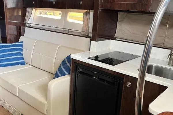  Yacht Photos Pics Interior of 2017 Sea Ray Sundancer 350 yacht with sofa, kitchenette, and modern amenities.