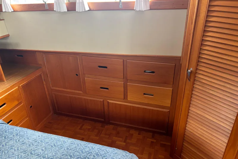  Yacht Photos Pics Wooden interior cabinetry of a 1991 Grand Banks 36 Classic boat, featuring drawers and louvered doors.