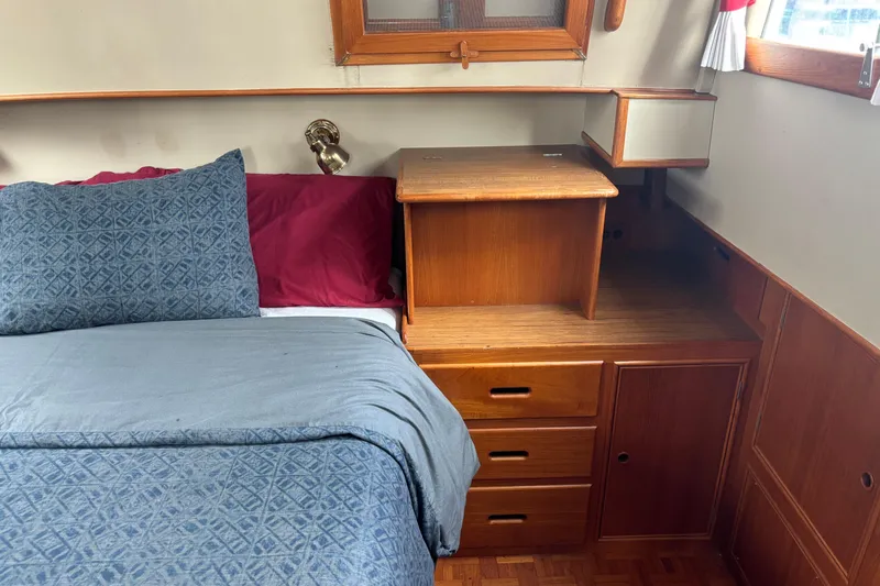  Yacht Photos Pics Cozy cabin interior of 1991 Grand Banks 36 Classic with wooden furniture and bedding.