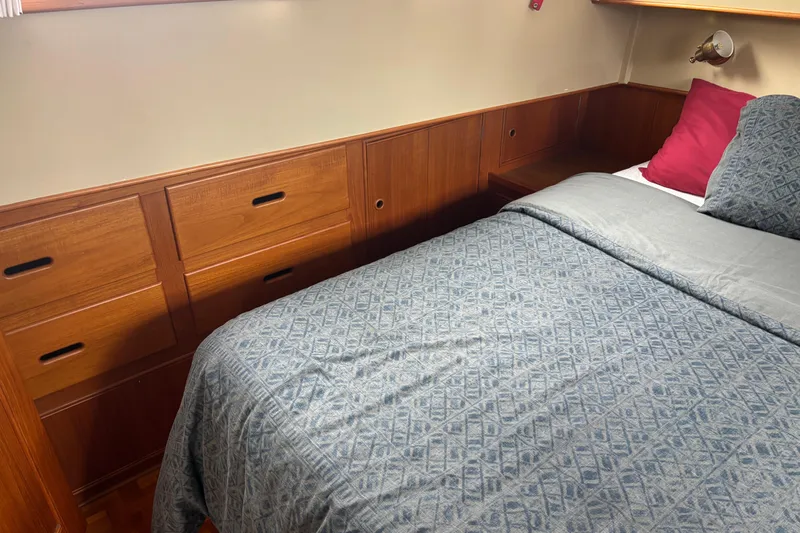 Yacht Photos Pics Cozy bedroom in 1991 Grand Banks 36 Classic yacht with wooden cabinetry and patterned bedding.