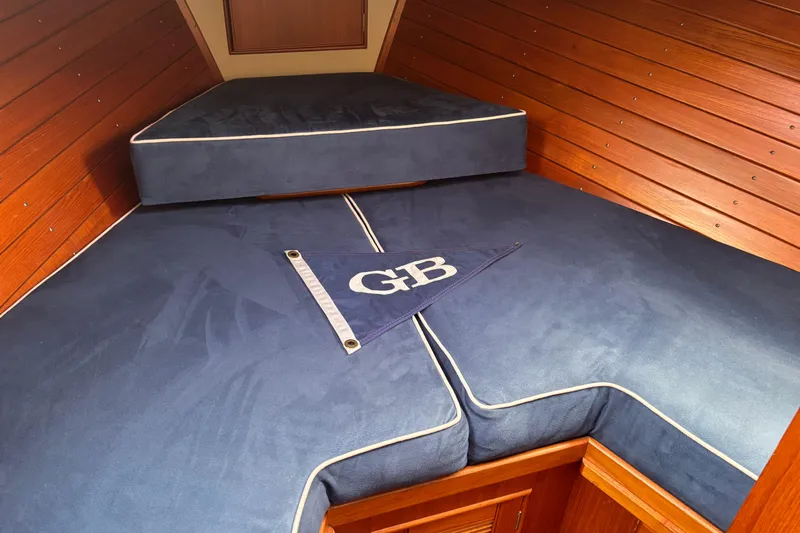  Yacht Photos Pics Cozy cabin interior of 1991 Grand Banks 36 Classic with blue cushions and wood paneling.