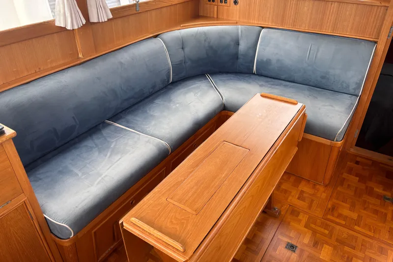  Yacht Photos Pics Cozy seating area in 1991 Grand Banks 36 Classic yacht with wooden table and blue cushions.