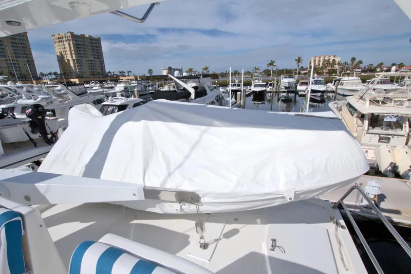 Wavos Rancheros Yacht Photos Pics 1999 West Bay 58 Sonship yacht at marina, covered deck, surrounded by boats.