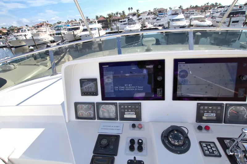 Wavos Rancheros Yacht Photos Pics Cockpit view of 1999 West Bay 58 Sonship yacht with navigation screens and marina background.