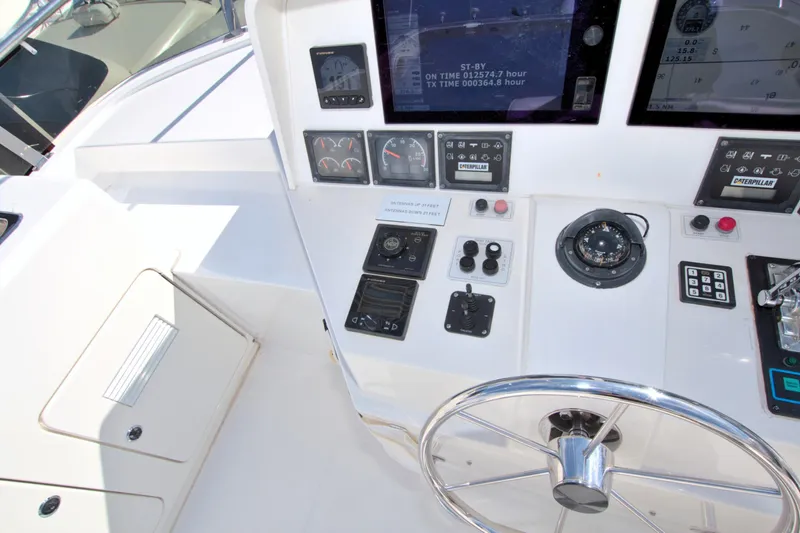 Wavos Rancheros Yacht Photos Pics Control panel of a 1999 West Bay 58 Sonship yacht, featuring navigation instruments and steering wheel.