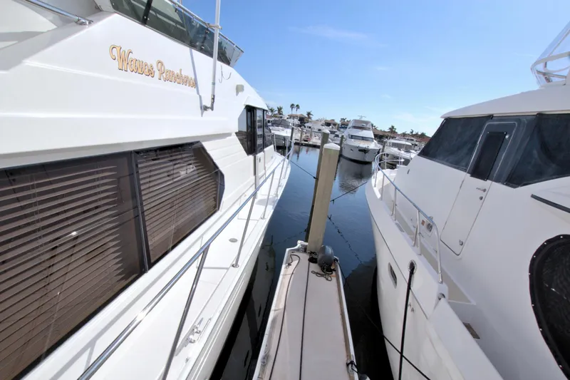 Wavos Rancheros Yacht Photos Pics Two yachts docked closely at a marina, featuring a 1999 West Bay 58 Sonship.