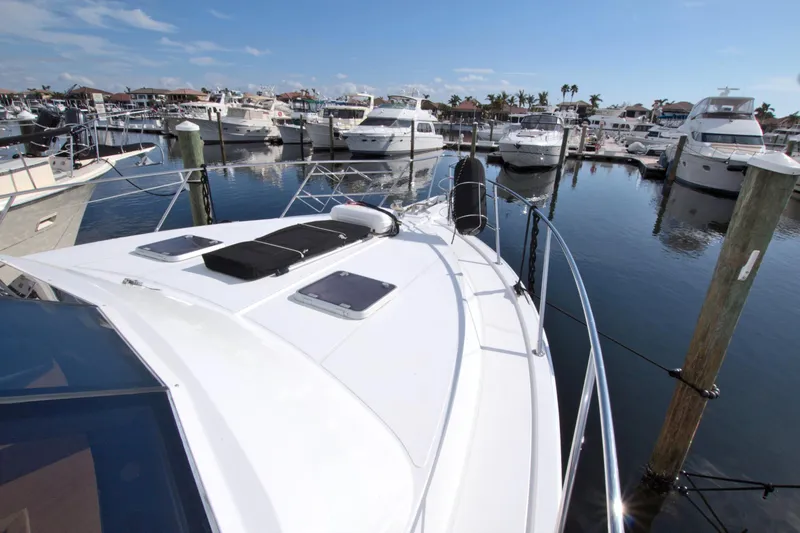 Wavos Rancheros Yacht Photos Pics 1999 West Bay 58 Sonship yacht docked in a marina under clear skies.