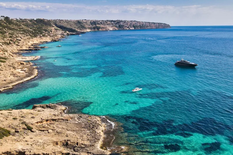 Smooth Operator Yacht Photos Pics Coastal view with Jongert 39m yacht, 2011, in clear turquoise waters.