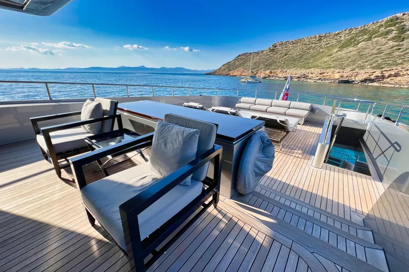 Smooth Operator Yacht Photos Pics Luxurious Jongert 39m yacht deck with elegant seating, overlooking serene coastal waters.