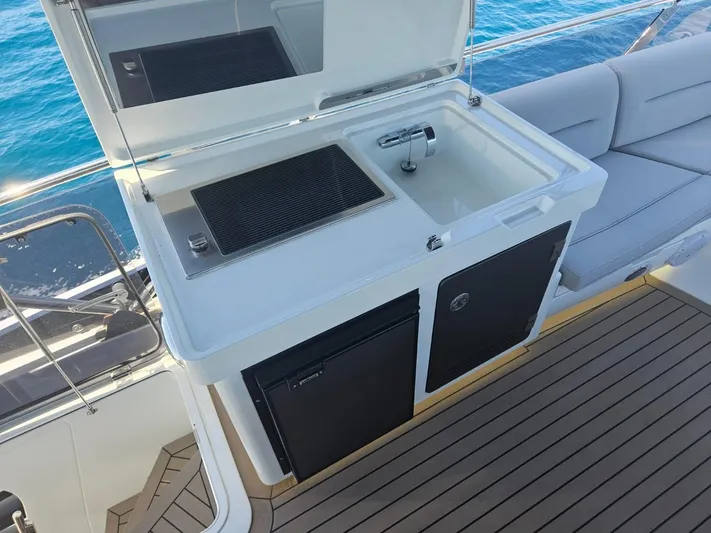  Yacht Photos Pics Outdoor kitchenette on 2024 Galeon 440 Fly yacht with sink and grill, overlooking ocean.