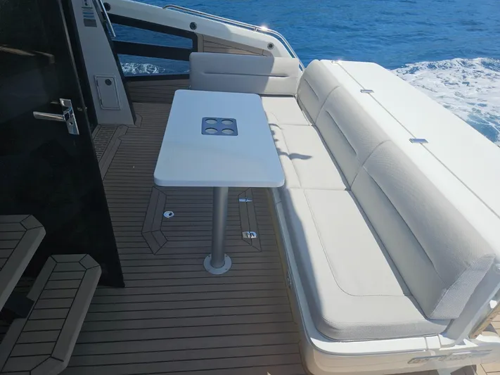  Yacht Photos Pics 2024 Galeon 440 Fly yacht deck with white seating and table, overlooking the ocean.