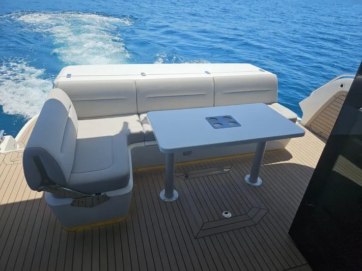  Yacht Photos Pics 2024 Galeon 440 Fly yacht deck with seating and table, cruising on blue ocean waters.