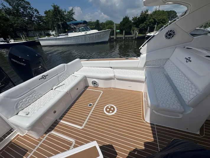  Yacht Photos Pics Luxurious seating area on a 2025 Fountain 39 DX boat, docked by the water.