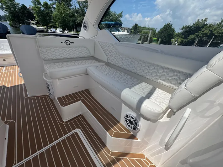  Yacht Photos Pics Luxurious seating on 2025 Fountain 39 DX boat with elegant white upholstery and wood-patterned flooring.