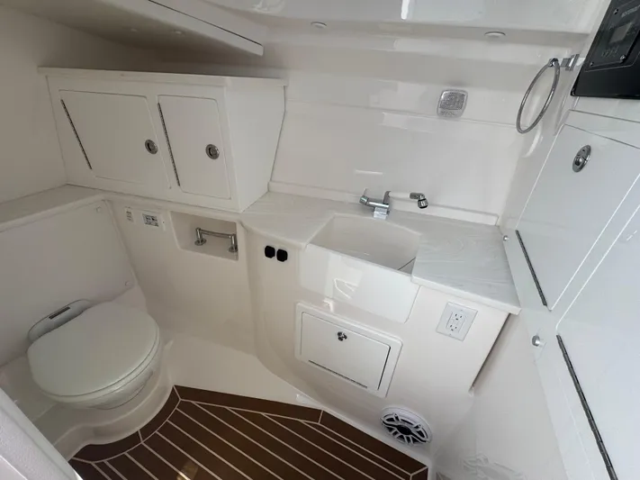  Yacht Photos Pics 2025 Fountain 39 DX boat bathroom with sink, toilet, and storage cabinets.