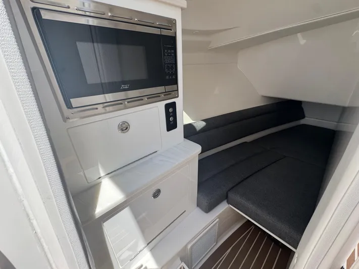  Yacht Photos Pics Interior of 2025 Fountain 39 DX boat with microwave and cushioned seating area.