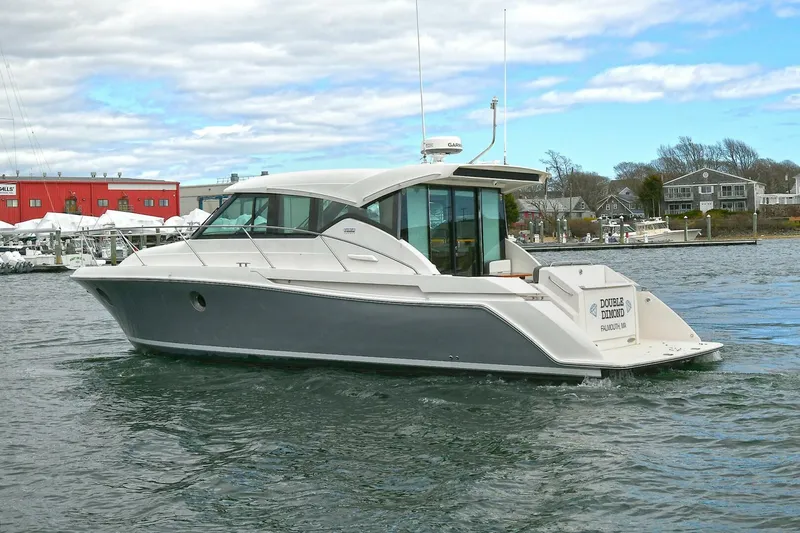 Double Diamond Yacht Photos Pics 2018 Tiara Yachts 39 Coupe cruising on a calm waterway, showcasing sleek design and luxury.