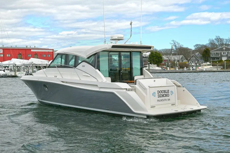Double Diamond Yacht Photos Pics 2018 Tiara Yachts 39 Coupe cruising in a marina with red building backdrop.