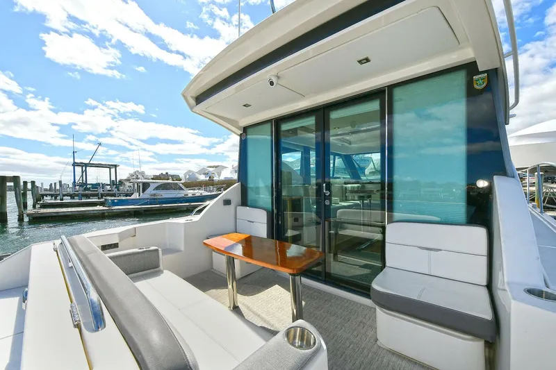 Double Diamond Yacht Photos Pics 2018 Tiara Yachts 39 Coupe with sleek seating and table on deck, docked at marina.