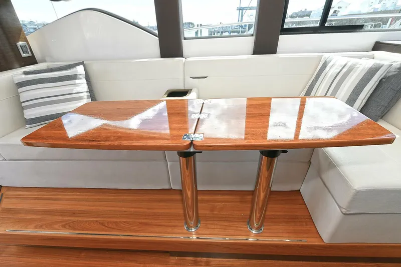 Double Diamond Yacht Photos Pics Interior of 2018 Tiara Yachts 39 Coupe with wooden table and cushioned seating.