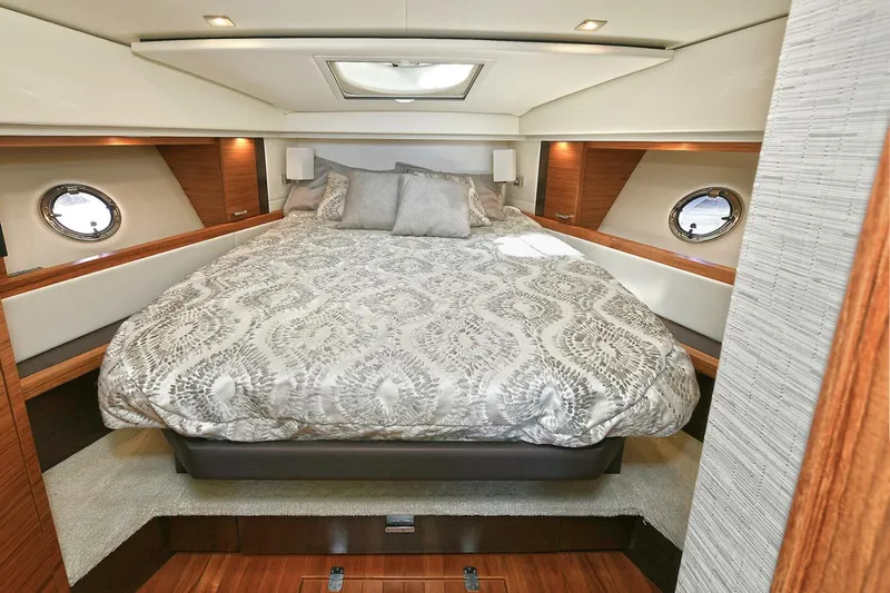 Double Diamond Yacht Photos Pics Luxurious bedroom interior of 2018 Tiara Yachts 39 Coupe with elegant bedding and porthole windows.