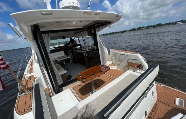  Yacht Photos Pics 2020 Jeanneau NC 37 yacht with open deck, wooden flooring, and scenic water view.