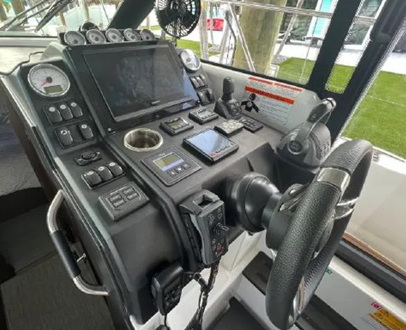  Yacht Photos Pics Control panel of a 2020 Jeanneau NC 37 boat with steering wheel and navigation equipment.