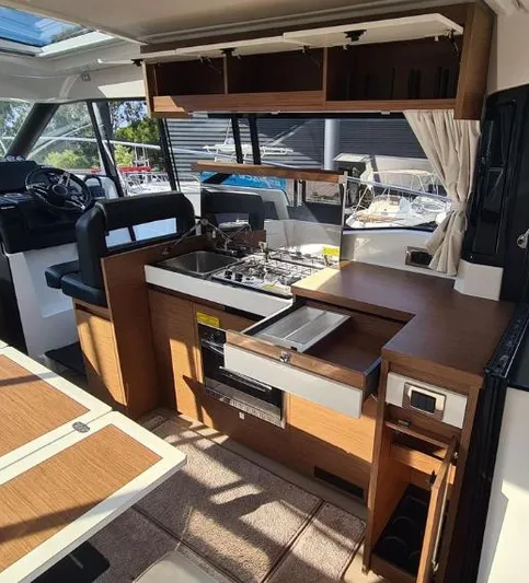  Yacht Photos Pics 2020 Jeanneau NC 37 yacht interior with modern kitchen and dining area.