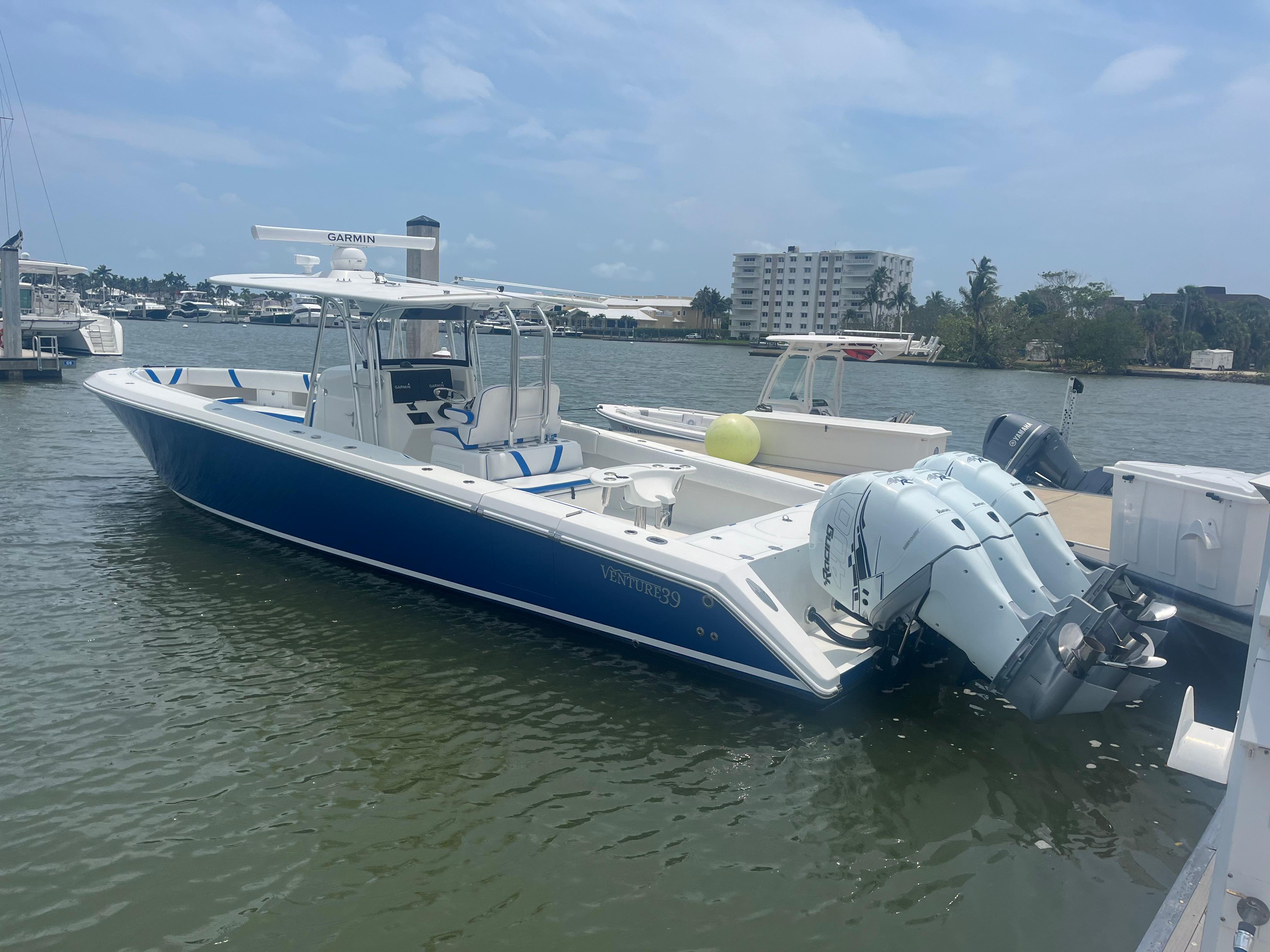 2016 Venture 39 Forward Seating boat docked with triple outboard engines.