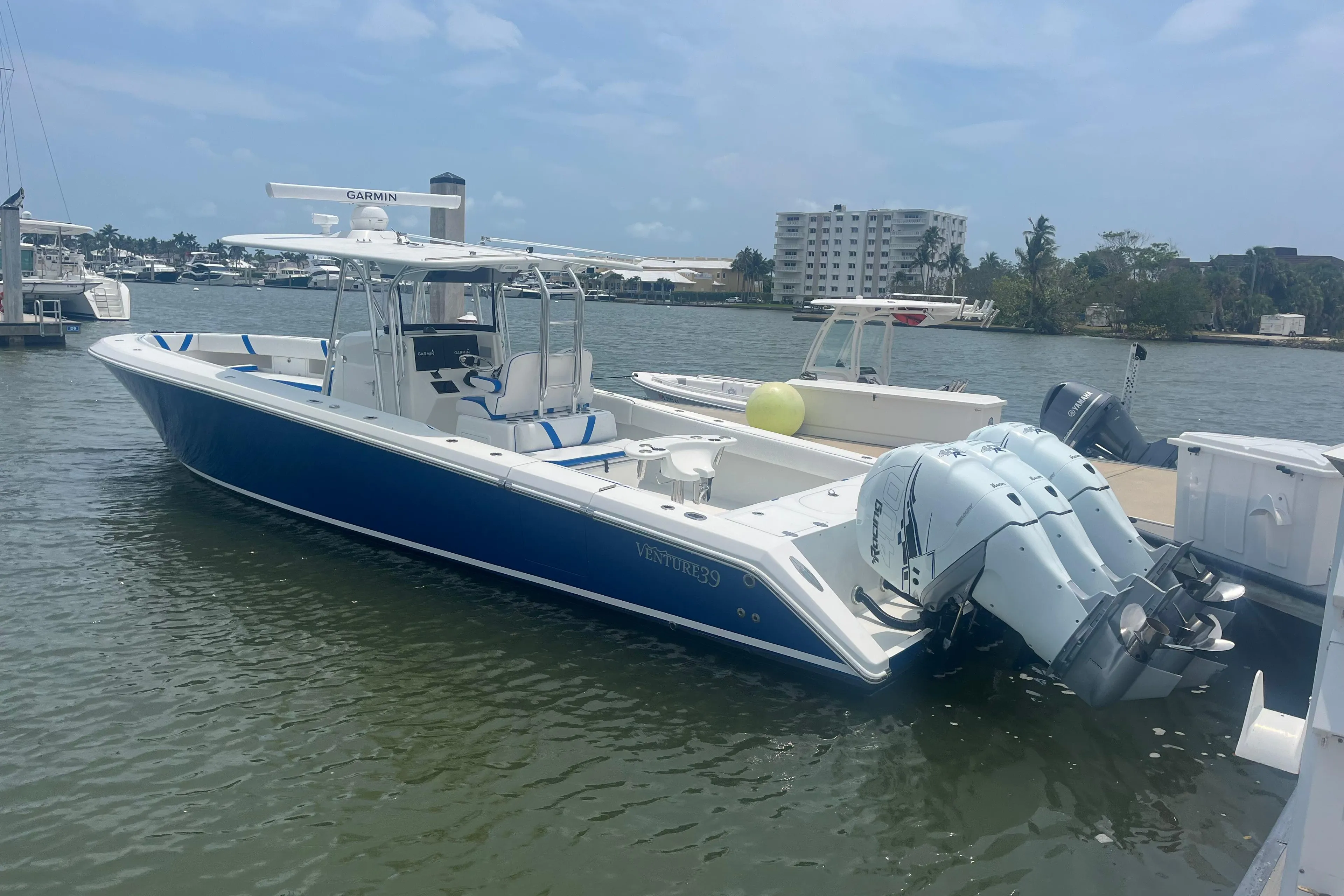 2016 Venture 39 Forward Seating boat docked with triple outboard engines.