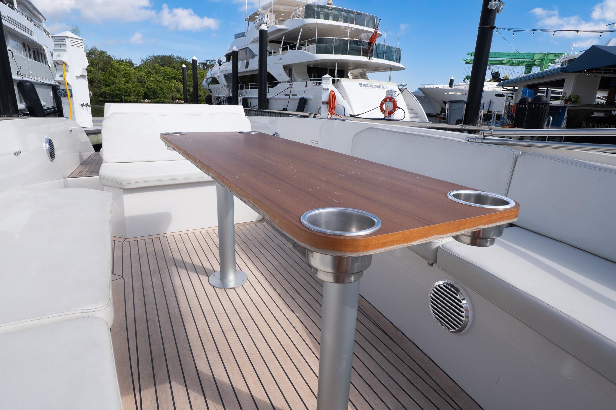 Luxurious 2022 Rand 23 Mana yacht interior with sleek wooden table and comfortable seating.