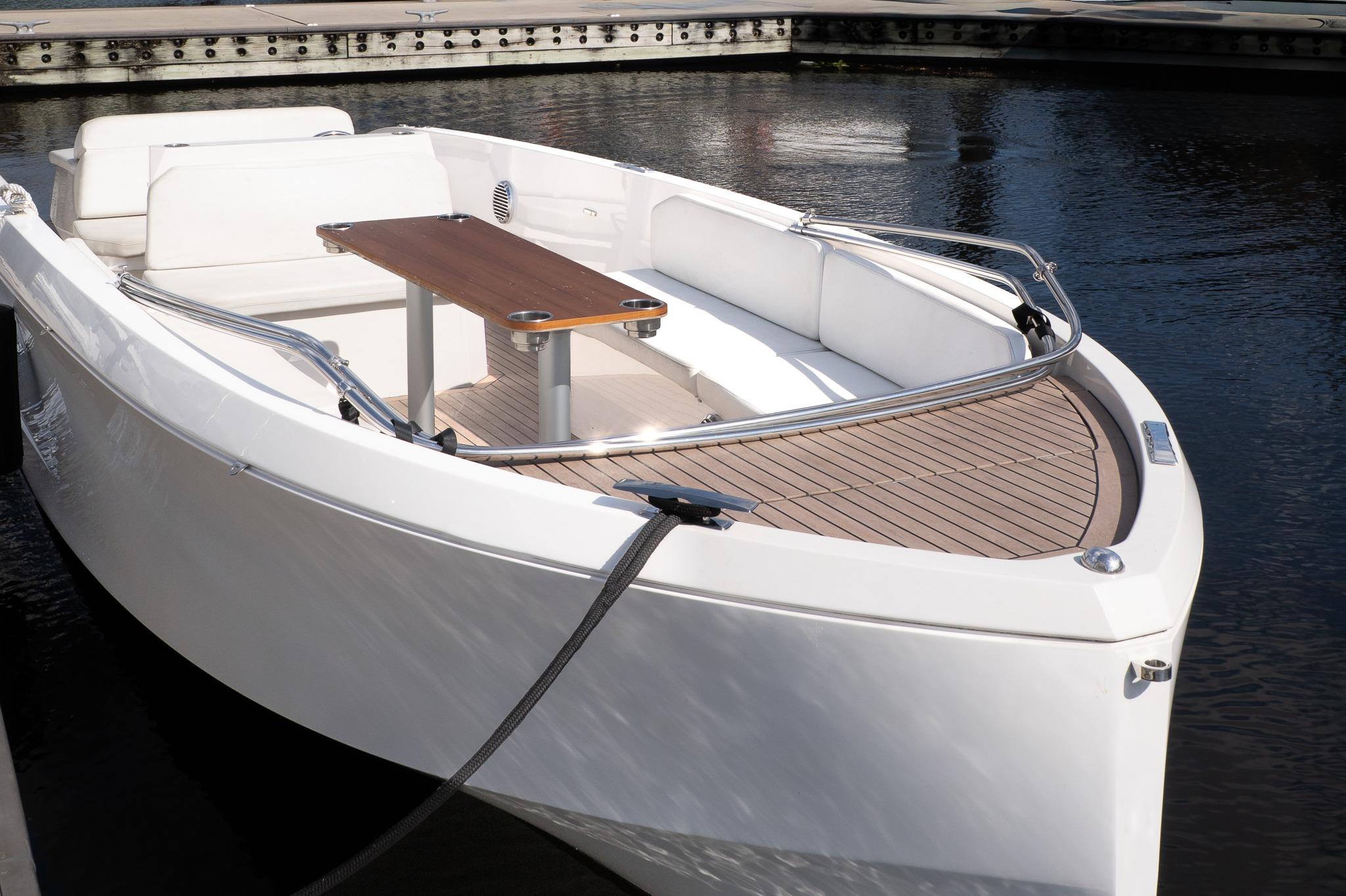 2022 Rand 23 Mana boat with sleek design, docked on calm water.