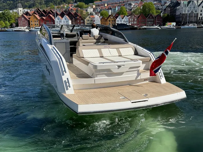  Yacht Photos Pics 2023 Windy 37 Shamal luxury boat cruising in scenic harbor with colorful buildings.