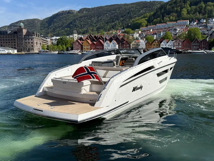  Yacht Photos Pics 2023 Windy 37 Shamal yacht cruising in scenic waters with hillside backdrop.