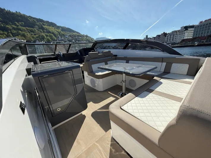  Yacht Photos Pics Luxurious 2023 Windy 37 Shamal yacht interior with elegant seating and table, docked by scenic waterfront.