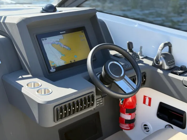 Yacht Photos Pics Control panel of 2023 Windy 37 Shamal boat with navigation screen and steering wheel.