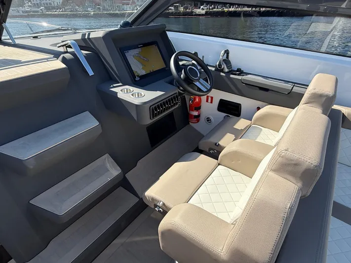  Yacht Photos Pics Modern helm of 2023 Windy 37 Shamal boat with steering wheel and navigation display.