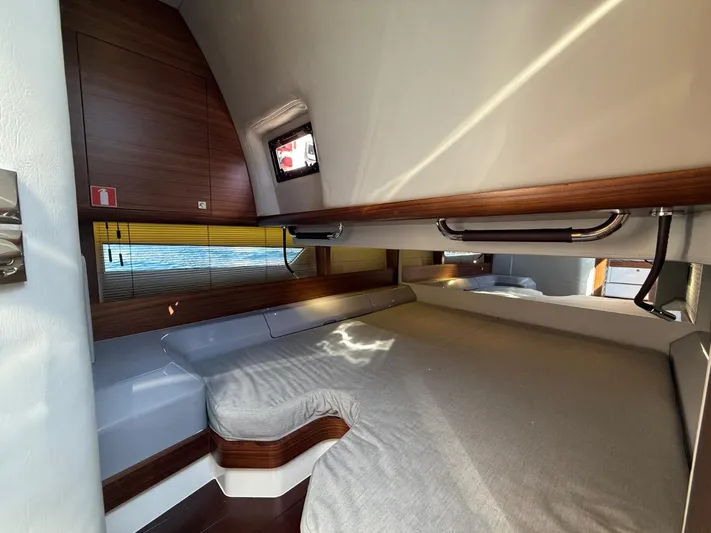  Yacht Photos Pics 2023 Windy 37 Shamal cabin interior with wooden accents and a cozy bed.