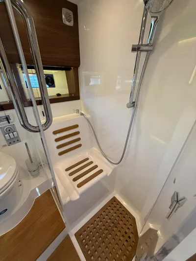  Yacht Photos Pics 2023 Windy 37 Shamal yacht bathroom with shower, wooden seat, and modern fixtures.