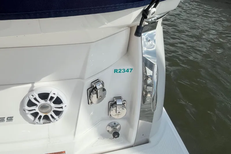  Yacht Photos Pics 2023 Regal 28 Express boat stern with speaker and chrome fittings near water.