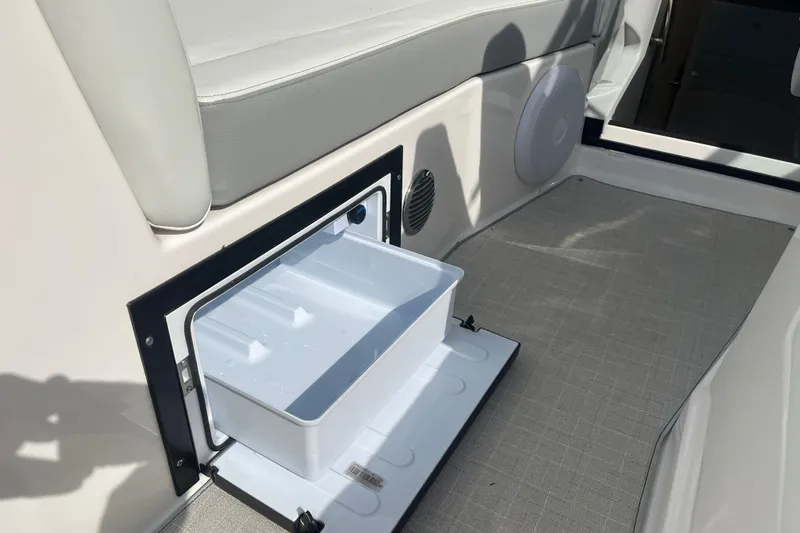  Yacht Photos Pics 2023 Regal 28 Express boat interior with open storage compartment and seating area.