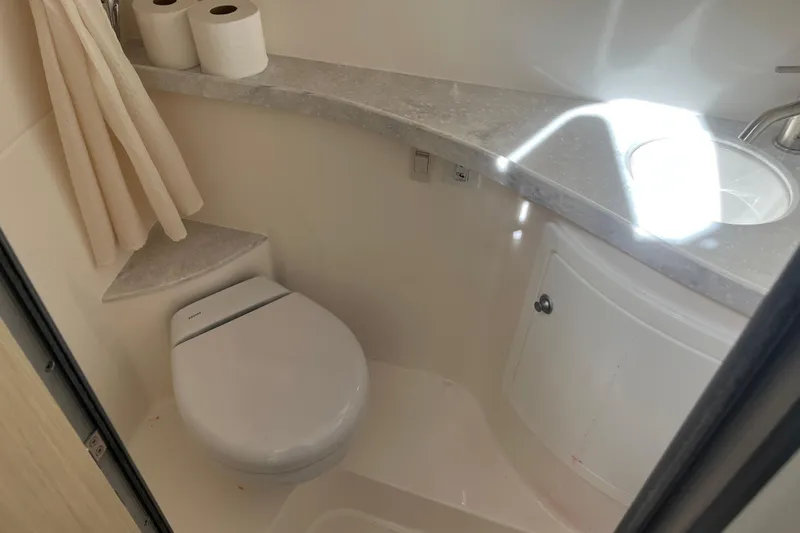  Yacht Photos Pics 2023 Regal 28 Express bathroom with toilet, sink, and storage cabinet.